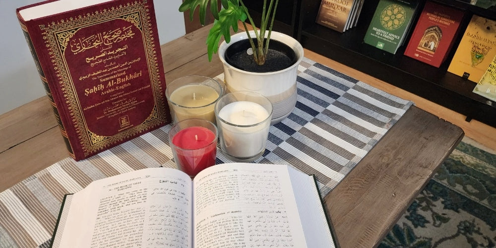 Books on a table with candles and a plant - the islamic book cafe